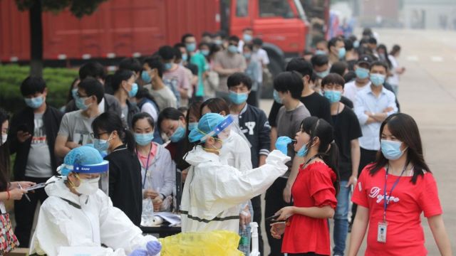 Medical workers take swabs from workers for the novel coronavirus test in a large factory in Wuhan in central China's Hubei province Friday, May. 15, 2020.