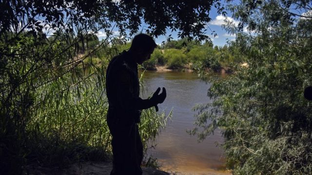 United States Border Patrol agent Robert Rodriquez looks across the Rio Grande into Reynosa, Mexico,