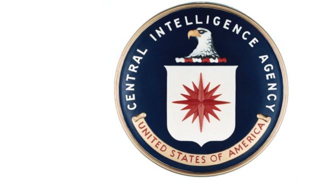 Selo circular com águia, estrela vermelha e a inscrição Central Intelligence Agency - United States of America