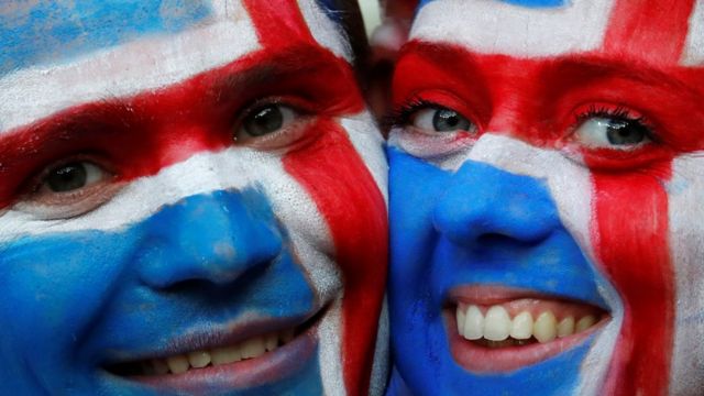 Dois torcedores com os rostos pintados com a bandeira da Islândia