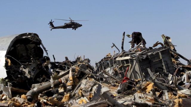 An Egyptian military helicopter flies over debris from a Russian airliner which crashed at the Hassana area in Arish city, north Egypt, November 1, 2015