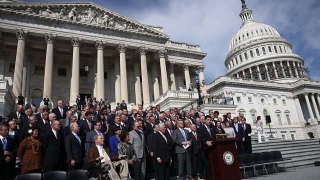 Legisladores entonan una canción patriótica "God Bless America" en las escalinatas del Capitolio, en Washington