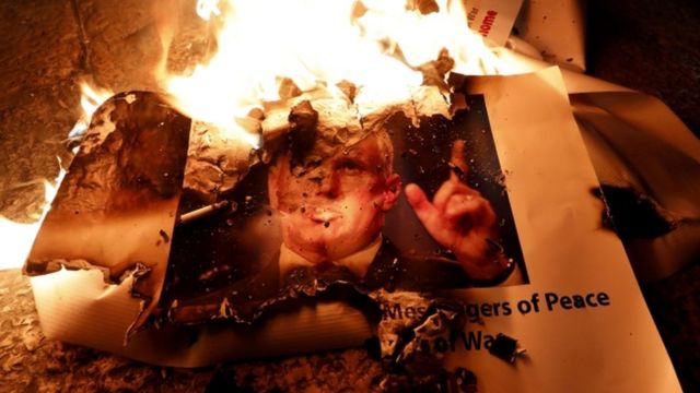 Manifestantes en Belén queman un póster de Mike Pence.