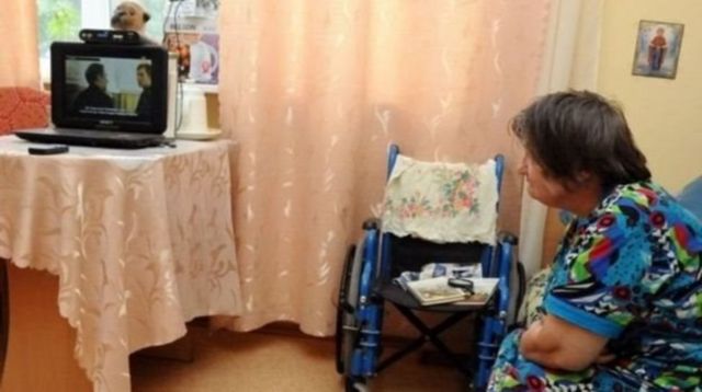 Бабуся дивиться телевізор