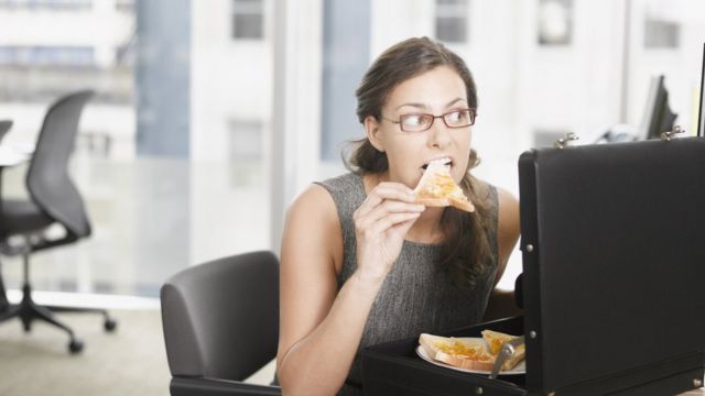 Mujer comiendo en el trabajo.
