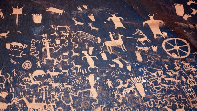 Una rueda entre los petroglifos -diseños simbólicos grabados en rocas- de Newspaper Rock State Historic Monument