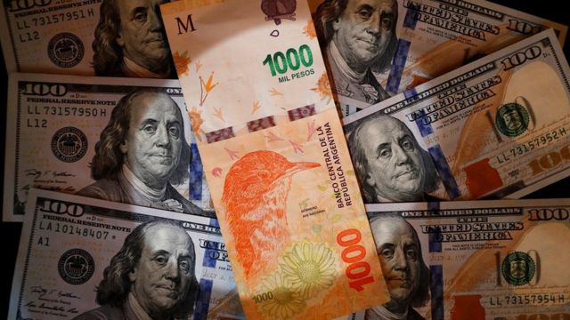 Nota de mil pesos em cima de notas de dólares