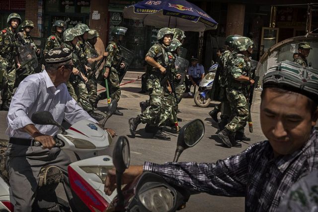 Chinese soldiers in riot gear secure the area outside the Id Kah Mosque, after Imam Jumwe Tahir was killed by assailants following early morning prayers on July 30, 2014 in old Kashgar, Xinjiang Uyghur Autonomous Region, China.