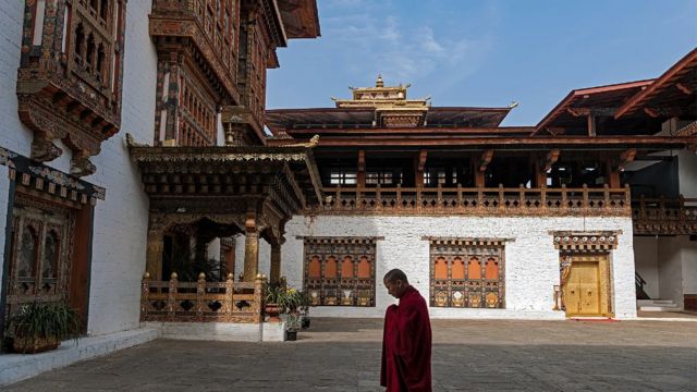 Um monge rezando em um mosteiro no Butão