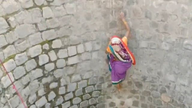 المرأة الهندية تتسلق جدار البئر.