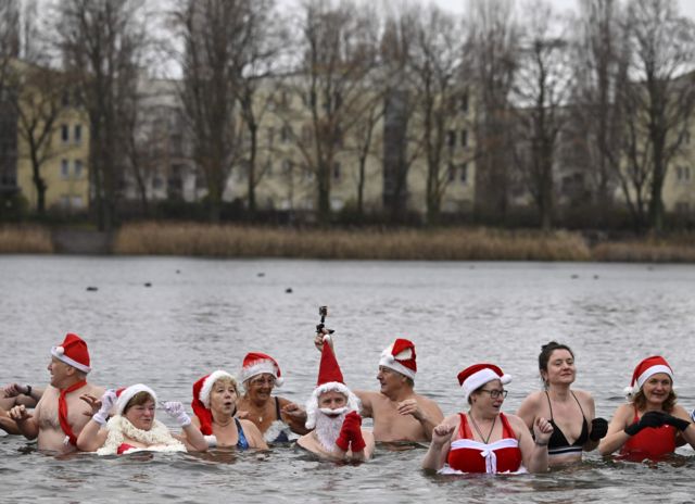 Members of a swimming club take their traditional Christmas bath at the Orankesee lake in Berlin