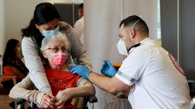 Elderly woman receiving a dose in Israel.