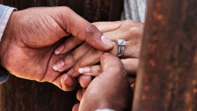 Un hombre coloca una alianza en el dedo de su prometida.