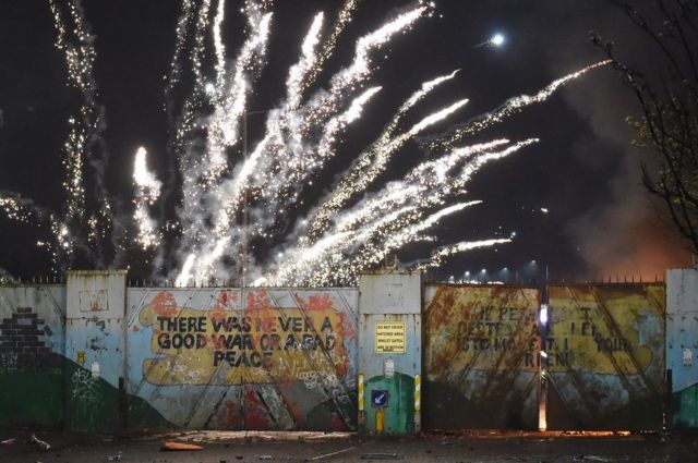 A firework exploding over a peace wall in west Belfast