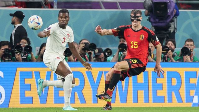 Belgian defender Thomas Meunier (right) wearing a black mask covering part of his face and Canadian defender Sam Adekugbe in their debut match at Qatar 2022 on November 23.