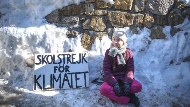 TOPSHOT - Swedish youth climate activist Greta Thunberg sits next to a placard reading "school strike for climate" on the sidelines of the World Economic Forum (WEF) annual meeting, on January 25, 2019 in Davos, eastern Switzerland. - Swedish 16-year-old Greta Thunberg has inspired a wave of climate protests by schoolchildren around the world after delivering a fiery speech at the UN climate summit in Katowice, Poland last month. (Photo by Fabrice COFFRINI / AFP) (Photo credit should read FABRICE COFFRINI/AFP/Getty Images)