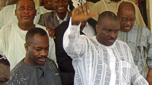 Le Chef James Ibori (au premier plan en blanc) lève sa main pour remercier ses sympathisants à sa sortie du palais de justice d'Asaba le 17 décembre 2009