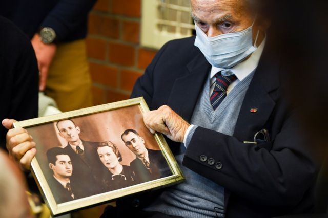 Holocaust survivor Leon Schwarzbaum holds a picture in the courtroom during a trial against a 100-year-old former security guard of the Sachsenhausen concentration camp, at the Landgericht Neuruppin court in Brandenburg, Germany, 7 October 2021