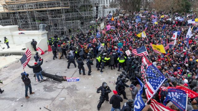 Policiais do Capitólio tentando conter partidários de Trump.