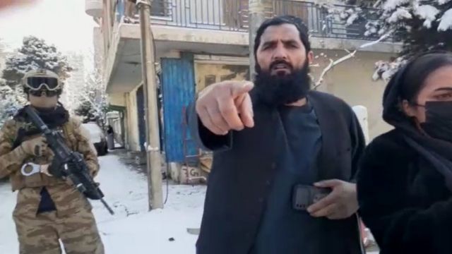 یک عضو طالبان در حال برخورد با معترضان زن
