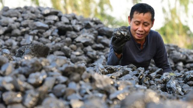 Un hombre en un patio de carbón en Hanoi.