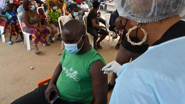 عاملة في القطاع الطبي أثناء تطعيم مواطن في مدينة أبيدجان في ساحل العاج