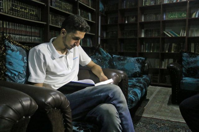 Joven leyendo en la biblioteca secreta de Siria.