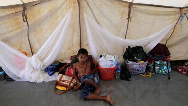 A Rakhine Buddhist boy who fled from recent violence in Maungdaw passes his time in a temporary shelter at a stadium in Sittwe