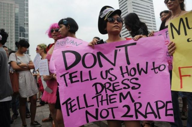 An Indonesian woman holds up a pink sign with black lettering on it, reading "don't tell us how to dress, tell them not to rape", at a protest in Jakarta on 18 September 2011, against remarks made by Jakarta City Governor Fauzi Bowo that partly blamed a gang-rape on the victim's choice of clothing.