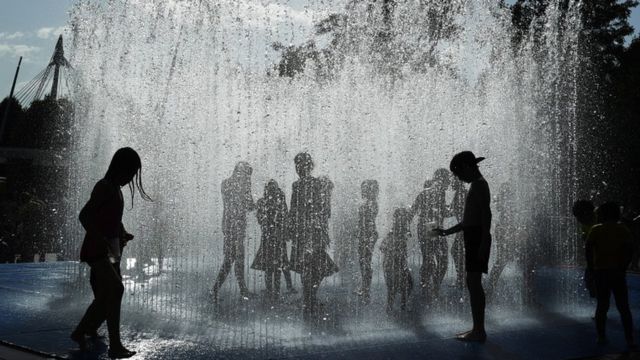 بچه ها خود را با آب فواره هایی در یک پارک در حاشیه رود تمز لندن خنک می کنند
