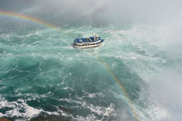 Un barco atravesado por un arcoíris