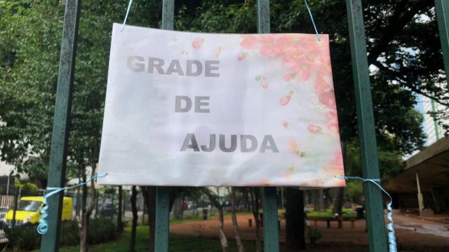 Placa de doação com placa onde se lê "grade se ajuda"