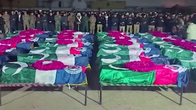 Lines of coffins draped in Pakistan flags