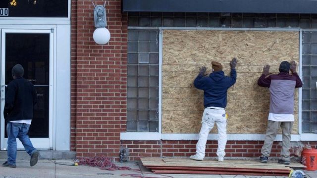 Dos trabajadores cubren con tablas un escaparate en el centro de Memphis