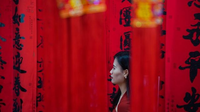 A woman in Nanning, Guangxi buys red lanterns and couplet decorations ahead of the upcoming Chinese New Year