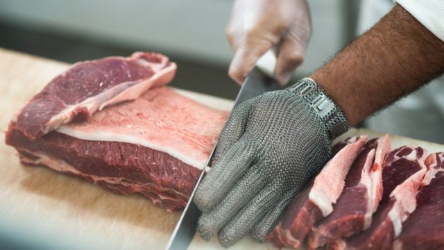 Homem cortando carne em filés