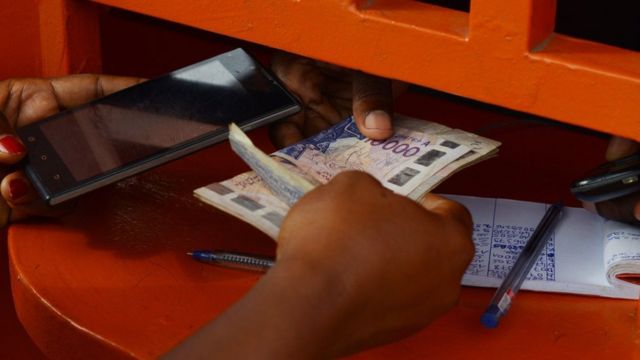 Une femme retire de l'argent à une caisse d'Orange Money à Abidjan. Ce système de paiement par téléphone mobile permet aux clients d'utiliser leur téléphone pour payer leurs factures ou pour transférer des fonds