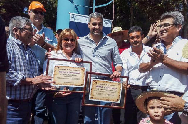 Sarah Lopez, Managing Director of Senasa, and President of Paraguay Mario Abdo Benítez receive recognition from the Ñupy San Rafael community, after the opening of a new water well.