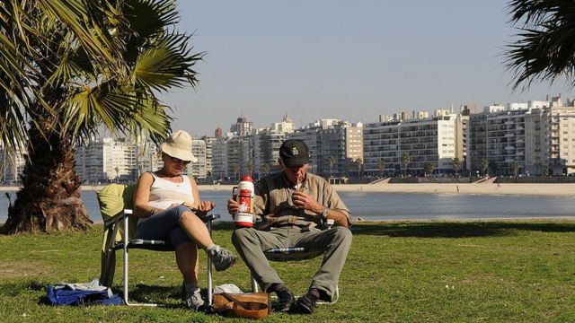 Duas pessoas bebem mate na Rambla de Montevidéu