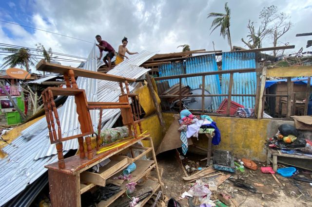 Personas intentan restaurar el techo de sus casas destruidas, 20 de diciembre de 2021