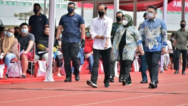 Presiden Joko Widodo (kiri) didampingi Gubernur Jawa Barat Ridwan Kamil (kanan) dan Bupati Bogor Ade Yasin (tengah) meninjau vaksinasi massal di Stadion Pakansari, Cibinong, Kabupaten Bogor, Jawa Barat, Kamis (17/06).