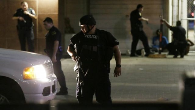 Dallas police detain a driver after sniper shootings