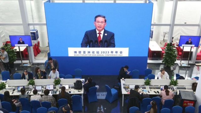 Journalists watch a screen showing China's Premier Li Qiang delivering a speech during the opening of the Boao Forum for Asia in Boao, south China's Hainan province on March 30, 2023.