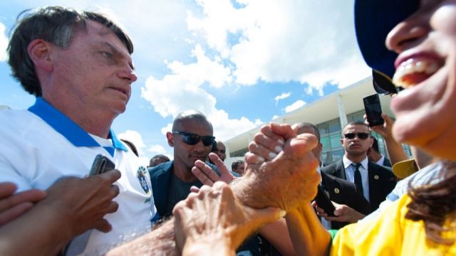 President Jair Bolsonaro shakes hand with a supporter on 15 March, amidst the Covid-19 outbreak in Brazil, 15 March