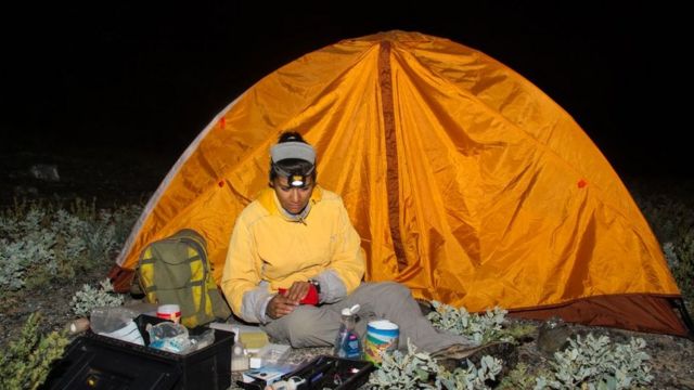 Yuliana Bedolla en una carpa de noche haciendo trabajo de campo