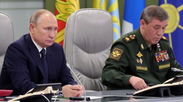 الرئيس الروسي فلاديمير بوتين (يسار) يجلس بجانب نائب وزير الدفاع في مركز التحكم للدفاع الوطني