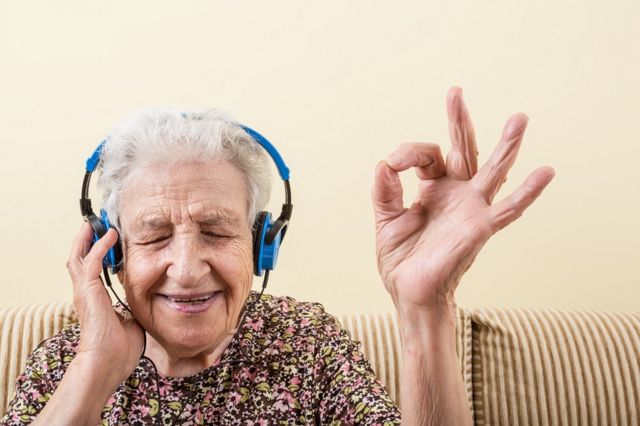 Elderly lady listening to a book in her headphones