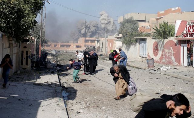 Orang-orang berlarian dalam panik setelah serangan udara pasukan koalisi terhadap posisi-posisi militan ISIS di kawasan Tahrir di kota Mosul,