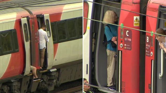 Passengers by open doors on stopped train