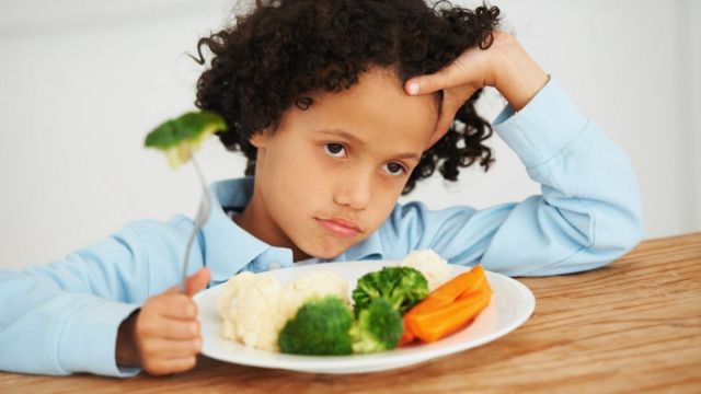 Niño negándose a comer vegetales.